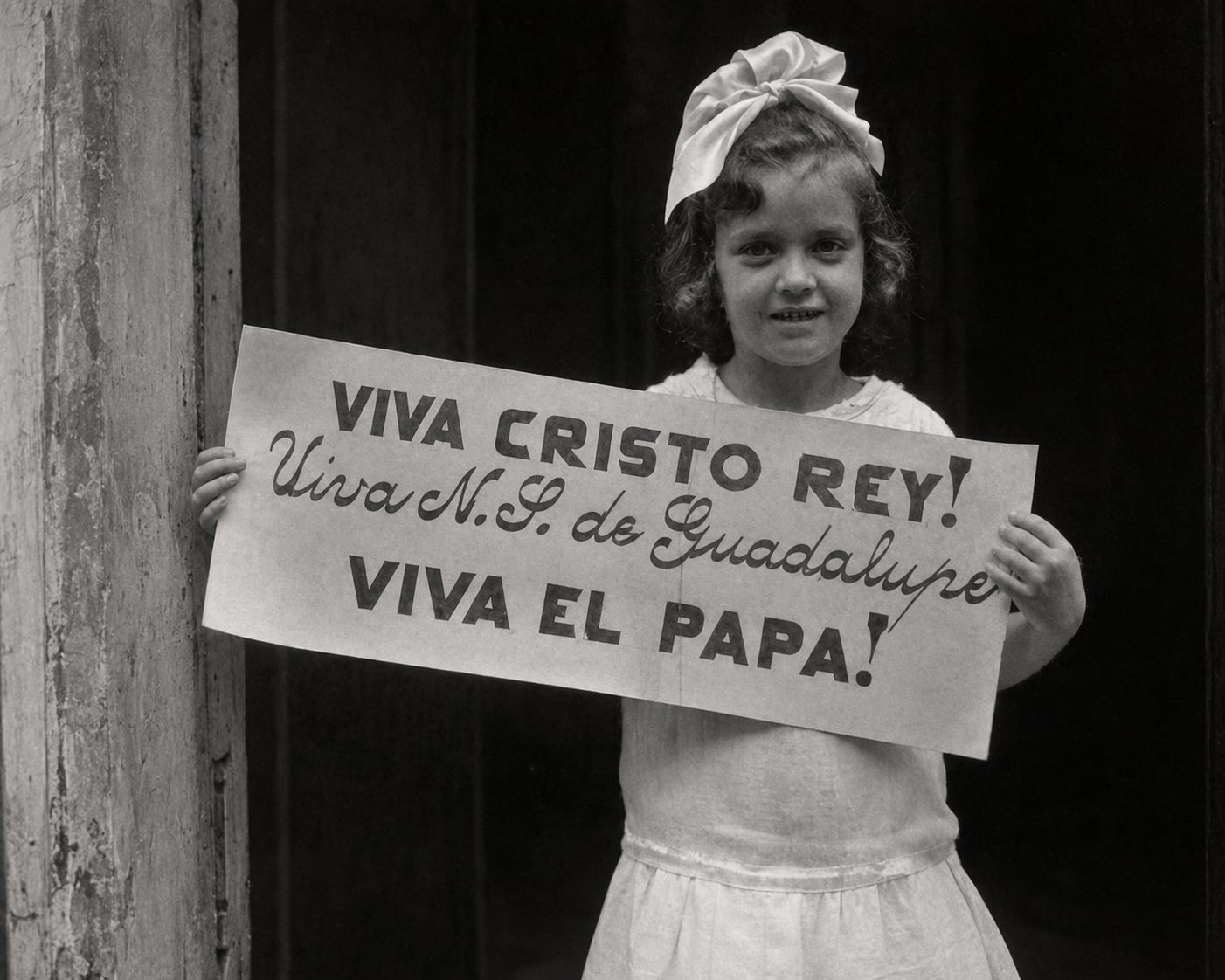 Niña sosteniendo un cartel que dice Viva Cristo Rey, Viva Nuestra Señora de Guadalupe, Viva el Papa